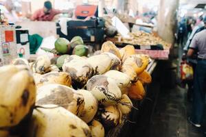 Yellow coconuts are sold in the market of the island of Mauritius. Sale of vegetarian fruits in the open air. Many coconuts on the market photo