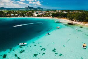 Aerial photography of the East coast of the island of Mauritius. the blue lagoon of the island of Mauritius is shot through from above. The boat is floating on a turquoise lagoon photo