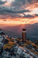 ai generado un al aire libre termo matraz soportes en un rock a puesta de sol foto