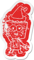happy cartoon distressed sticker of a robot waving hello wearing santa hat png
