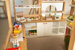 Wooden children's play kitchen with dishes and artificial food photo