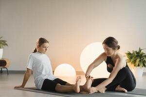 Mom and teenage daughter do gymnastics together in the fitness room. A woman and a girl train in the gym photo