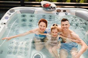 In summer, the family rests in the outdoor hot tub photo