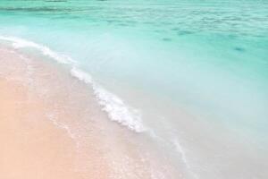 A view from a height of a Tropical beach and waves breaking on a tropical golden sandy beach. The sea waves gently wind along the beautiful sandy beach photo