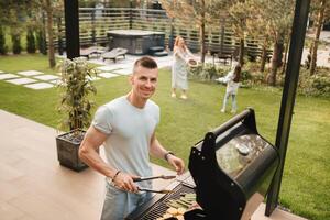 A man on the street is cooking a steak on the grill at a barbecue photo