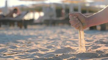 une homme verse le sable sur le plage. solitude et imitation de le qui passe de temps. video