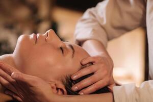 A cosmetologist girl does a facial and neck massage to a girl in the office for skin elasticity photo