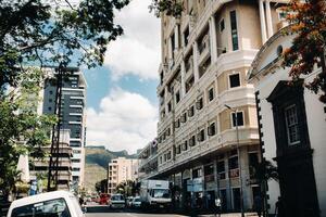 Port Louis, Mauritius view of a city street with heavy traffic. on the first floor of the building there is a cafe photo