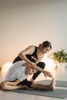 Mom and teenage daughter do gymnastics together in the fitness room. A woman and a girl train in the gym photo