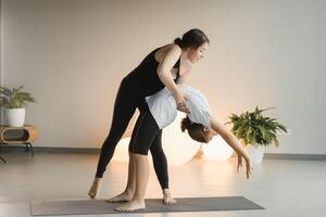 Mom and teenage daughter do gymnastics together in the fitness room. A woman and a girl train in the gym photo