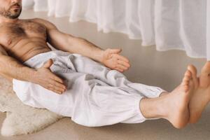 a man with a bare torso does yoga in a fitness room. the concept of a healthy lifestyle photo