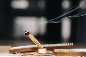 A smoking Palo Santo stick and boards with nails for yoga classes photo