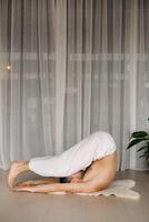 a man with a bare torso does yoga in a fitness room. the concept of a healthy lifestyle photo