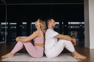 a woman and a man are engaged in pair gymnastics yoga in the gym photo