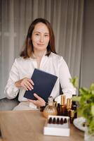 portrait of a smiling girl-woman sitting in an armchair. An aromatherapist in a white blouse is sitting in the office photo