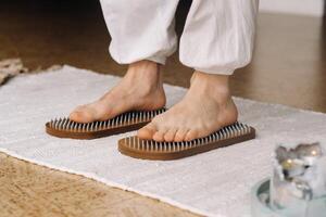 The man's feet are next to boards with nails. Yoga classes photo