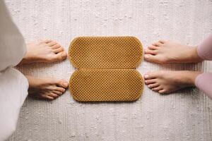 The legs of a man and a woman stand next to boards with nails for Yoga classes photo