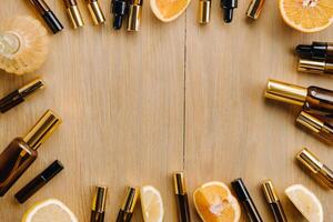 Essential oil in bottles and lemons, oranges lying on a wooden surface photo