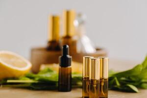 Essential oil in bottles with lemon and mint fragrance lying on a wooden surface photo