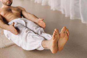 un hombre con un desnudo torso lo hace yoga en un aptitud habitación. el concepto de un sano estilo de vida foto