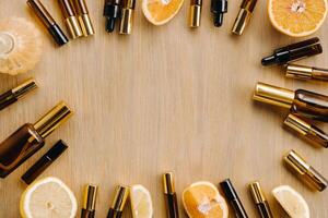Essential oil in bottles and lemons, oranges lying on a wooden surface photo
