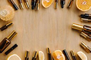 Essential oil in bottles and lemons, oranges lying on a wooden surface photo