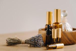 Essential oil in bottles with lavender fragrance, lying on a wooden surface photo