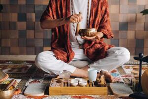 Tibetan singing bowl in the hands of a man during a tea ceremony photo