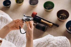 Close-up of a Tibetan singing bowl in your hands - Translation of mantras  transform your impure body, speech and mind into a pure exalted body, speech and mind of a Buddha photo