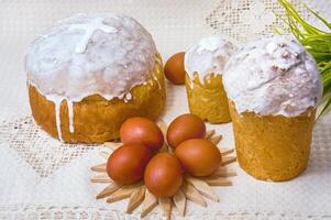 Easter cakes and red eggs on a linen napkin on a light background photo