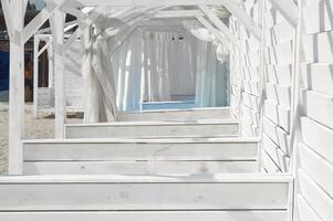 Wooden white arches on the beach. Summer vacation photo