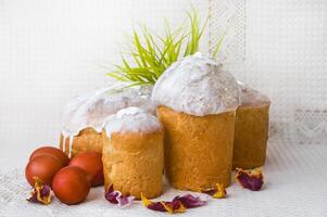 Easter cakes and red eggs on a linen napkin on a light background photo