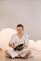 Portrait of a female yoga teacher playing a Tibetan bowl or singing a bell in the gym during a yoga retreat photo