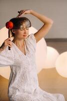 Portrait of a female yoga teacher playing a Tibetan bowl lying on her head in the gym during a yoga retreat photo