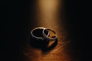 diseñador Boda anillos acostado en el superficie. dos Boda anillos foto