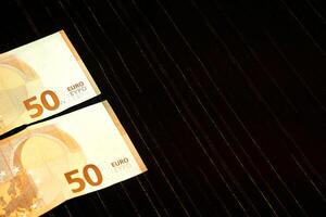dinero. dos 50 euro billetes en oscuro tela con lurex foto