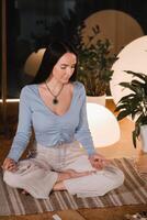 A young woman sitting in the Lotus position before the Game was playing and holding game cubes in her hand photo