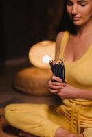 A girl in yellow clothes sitting on the floor holding pencils for drawing photo