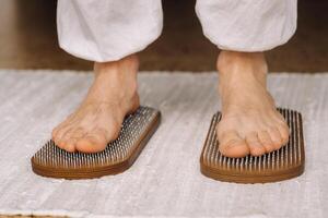 The man's feet are next to boards with nails. Yoga classes photo