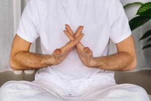 a man in white sportswear is doing yoga with a fitness room. the concept of a healthy lifestyle photo