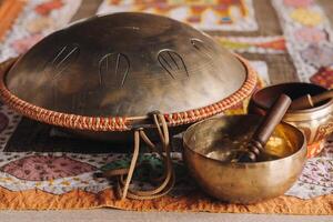 Tongue drum and Tibetan bowls lying on the carpet photo