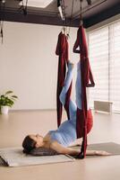 embarazada muchacha. un mujer lo hace yoga en un hamaca en el gimnasia. el concepto de un sano estilo de vida, maternidad foto