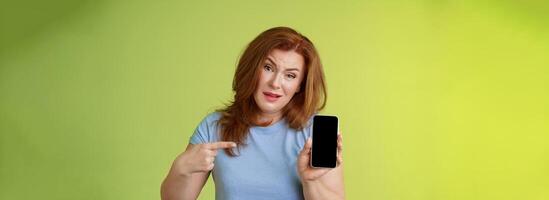 Have something say. Questioned serious-looking displeased redhead mature mother acting pissed hold smartphone pointing blank mobile phone screen demand answers found daughter social-media photos