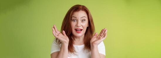 Glad surprised happy redhead middle-aged mother surprised gasping clap hands impressed wide gaze smiling broadly amazed unexpected family visit cheering positive news receive lucky chance celebrating photo