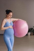 Pregnant woman during fitness classes with a fitball photo