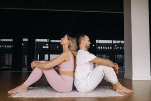 a woman and a man are engaged in pair gymnastics yoga in the gym photo