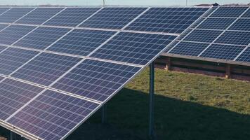 Photovoltaics solar panels in a solar park. Solar panels on green grass and blue sky. Solar panels system power generators. Alternative power energy concept. video