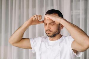 a man in white sportswear is doing yoga with a fitness room. the concept of a healthy lifestyle photo