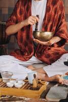 Tibetan singing bowl in the hands of a man during a tea ceremony photo