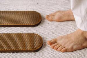 The man's feet are next to boards with nails. Yoga classes photo